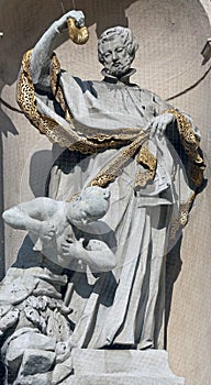 Statue of Saint on baroque Jesuits church in Vienna photo