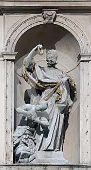 Statue of Saint on baroque Jesuits church in Vienna photo