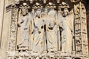 Statue of Saint Denis holding his head, Notre Dame cathedral photo