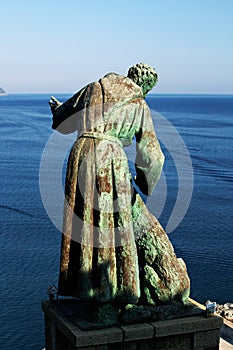 The statue of Saint Francis of Assisi caressing the wolf of Gubbio, Monterosso Al Mare, Cinque Terre, Italy. photo