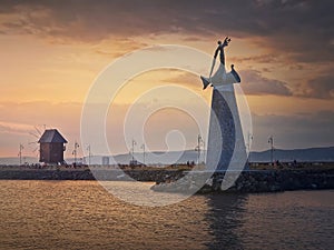 Statue of Saint Nicholas the patron of sailors, in the old town of Nessebar, Burgas, Bulgaria. Sunset scene at the coastline with