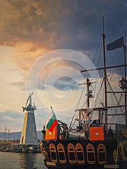 Statue of Saint Nicholas the patron of sailors, in the old town of Nessebar, Burgas, Bulgaria. Sunset scene at the coastline with