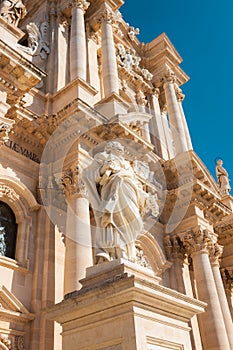 Statue of a Saint Peter in front of the facade of sicilian baroque catholic Cathedral of Syracuse