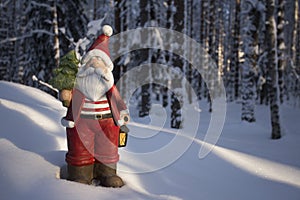 Statue of Santa Claus with a Christmas tree and lamp. Background.