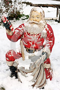 Statue of Santa Claus outdoors covered with snow