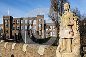 Statue of a school boy and the facade of the Amsterdam Lyceum a high school in Amsterdam South, Holland