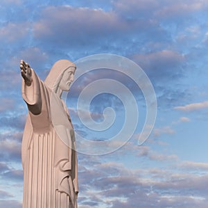 Statue sculpture of Jesus Christ the Savior. Background of blue sky and white clouds.