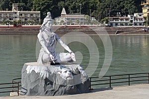 Statue of Shiva, Hindu idol near Ganges River water, Rishikesh, India. The first Hindu God Shiva. Sacred places for pilgrims