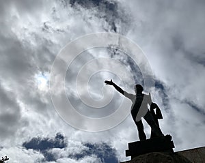A statue in the square of a town in Spain on a cloudy day in the light of noon photo