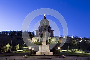 Statue of St. Andre in front of St. Josephâ€™s Oratory of Mount Royal at sunrise