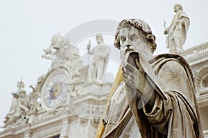 The statue of St. Paul in front of the facade of St. Peter`s basilica