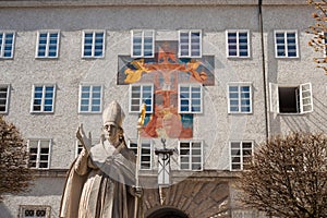 Statue of St. Rupert and fresco on the wall of St.Benedict college, Salzburg, Austria