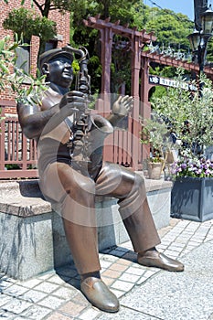 Statue of trumpet player in front of Weathercock House in historic area of Kitano district in Kobe, Japan