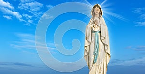 Statue of the Virgin Mary against blue sky photo