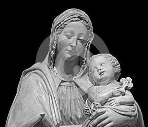 Statue of the virgin Mary carrying the baby Jesus isolated on black background. Mother of god sculpture, classic