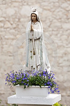 Statue of Virgin Mary with flowers