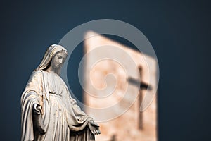 The statue of Virgin Mary in front of a modern church& x27;s tower