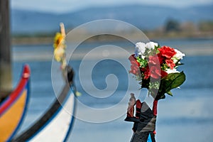 Statue of the Virgin surrounded by flowers on the bow of colorful typical boats