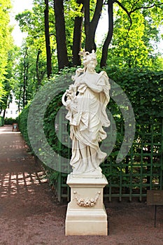 Statue of a woman in the park summer gardens.