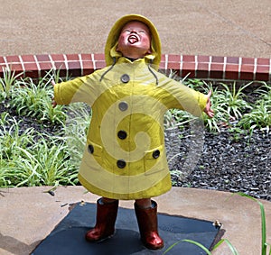 Statue of Young Child Playing In The Rain