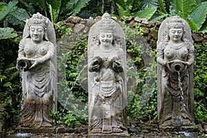 Statues in Bali Indonesia of a fountain with jungle in the back