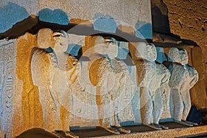 Statues at base of obelisk by entrance to Luxor Temple during night