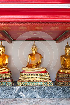 Statues of Buddha in Wat Pho temple, Bangkok Thailand. Golden statues are placed in row in ancient spiritual centre of Buddhism.