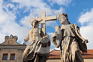 Statues of Christ and Man and Cross Against Blue Sky