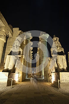 Statues and columns in hypostyle hall at Luxor Temple during night