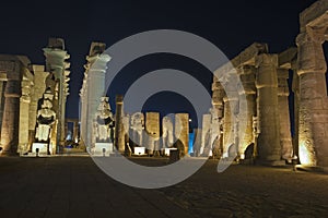 Statues and columns in hypostyle hall at Luxor Temple during night