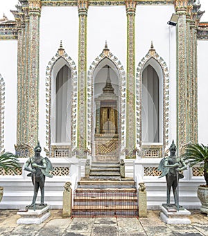 Statues of the guardian warriors at the gate of Phra Wiharn Yod Buddhist Temple in Bangkok, Thailand