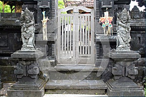 Statues guarding a temple and wooden door, Tanah Lot complex in Bali