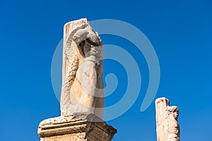 Statues of mythological heroes in Ancient Agora, Athens, Greece. View of big majestic statues on blue sky background in Athens