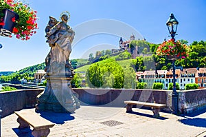Statues of St Mary stands on a dragon on the Old Main Bridge. Summer cityscape. Wurzburg is a city located on Main River. Germany