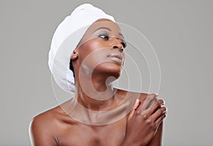 Statuesque beauty. Beauty shot of a young woman with a towel around her head posing in studio.