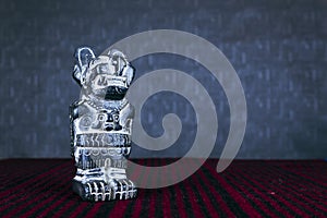 Statuette, Andean Puma, Puma Punku. Isolated on dark background and Indian aguayo. photo