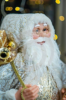 Statuette of Santa Claus. Beautiful big doll of Santa Claus. Bokeh lights..