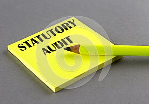 STATUTORY AUDIT text written on a sticky on grey background