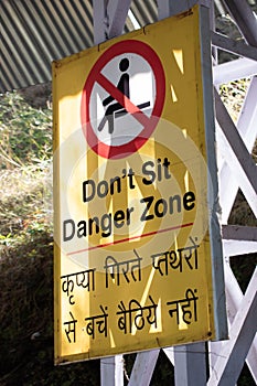 Statutory warning for falling stones in a danger zone on a yellow sign board