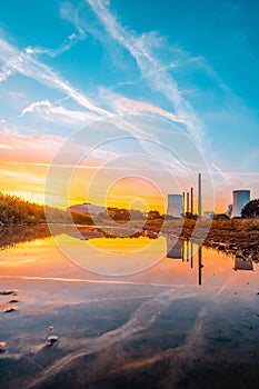 Staudinger coal-fired power plant, Bavaria, Germany. In the morning, sunrise with landscape, everything is reflected in a puddle