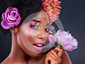 Stay fabulous. Studio shot of a beautiful young woman posing with flowers in her hair.