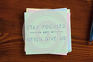 Stay focused and never give up written on note