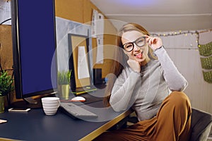 Stay home, a chic girl works in a homely atmosphere. Girl freelancer working at a computer with glasses