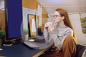 Stay home, a chic girl works in a homely atmosphere. Girl freelancer working at a computer with glasses