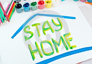 Stay at home. Children`s drawing with gouache paints on a white sheet.Campaign on social networks for the prevention of