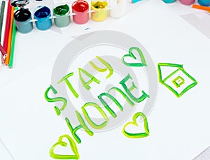 Stay at home. Children`s drawing with gouache paints on a white sheet.Campaign on social networks for the prevention of