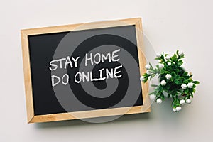 STAY HOME DO ONLINE text in white chalk handwriting on a blackboard