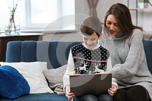 Stay home. Portrait of smiling mother and son using laptop for a online meeting, video call, video conference with