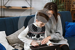 Stay home. Portrait of smiling mother and son using laptop for a online meeting, video call, video conference with