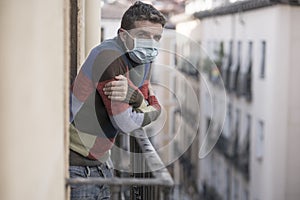 Stay home quarantine portrait of of 30s handsome man in face mask sad and depressed at home balcony during covid19 lockdown